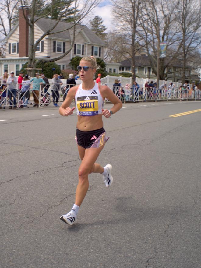 A woman with white shirt and shoes and black shorts. Her bib reads &ldquo;Scott&rdquo;