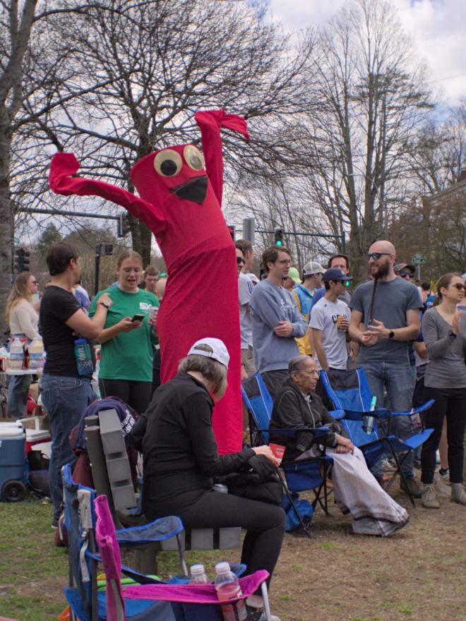 A person dressed as an arm-flailing tube man waves from the sidelines